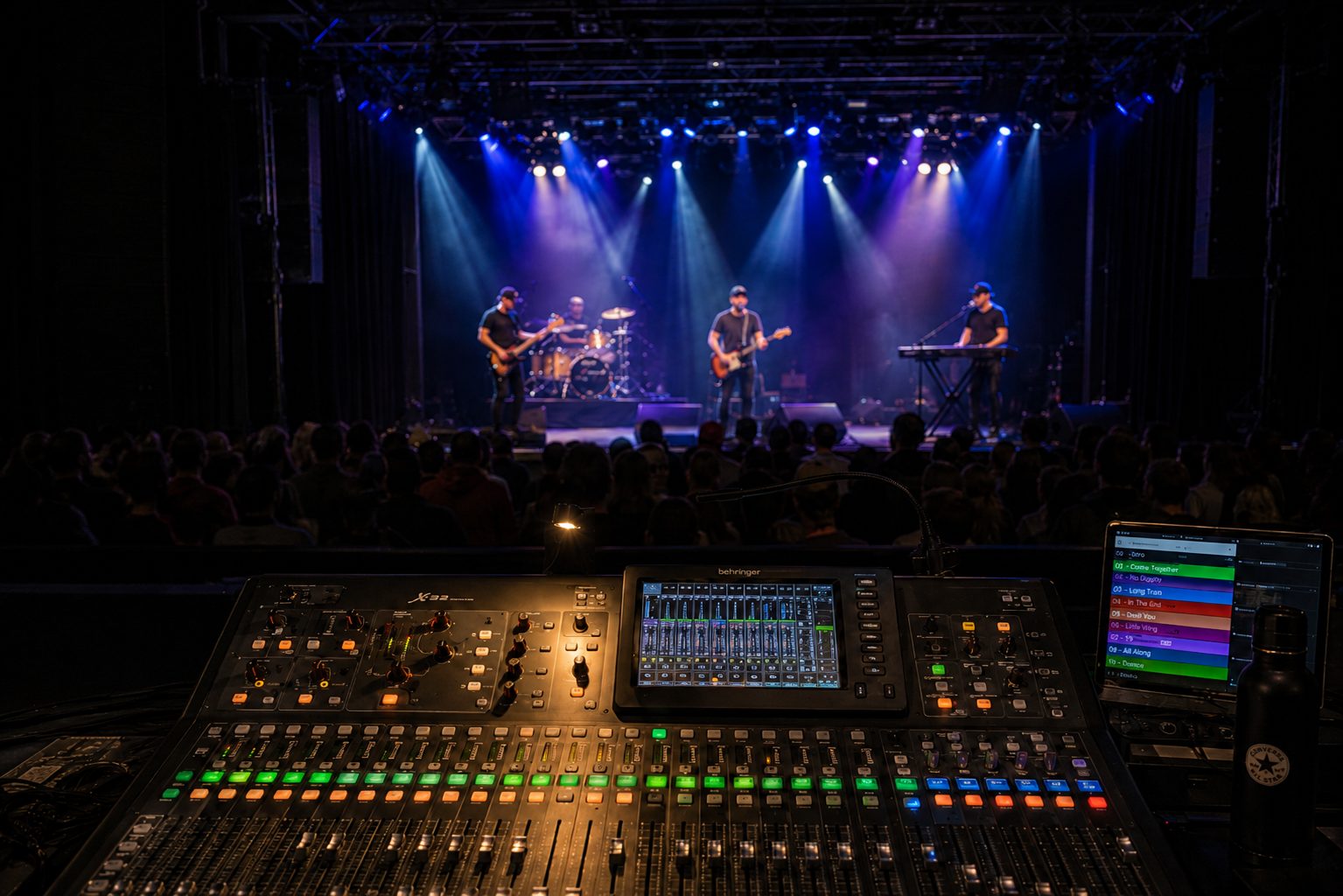 Behringer X32 console at front of house with the band on stage